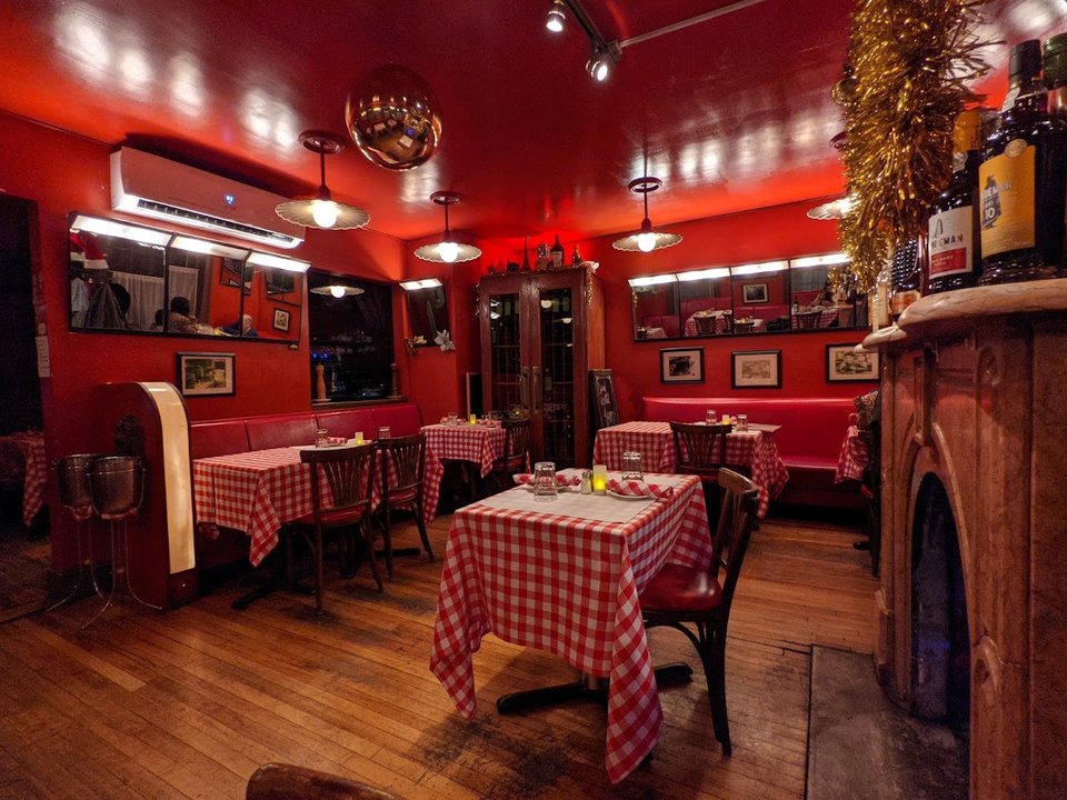 Cozy red dining room with white table settings.